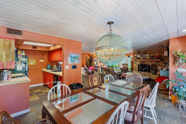 4842 W Fm 2147, Horseshoe Bay, TX 78657 - dining room with a fireplace, wooden ceiling, a chandelier, and dark stone finish floors