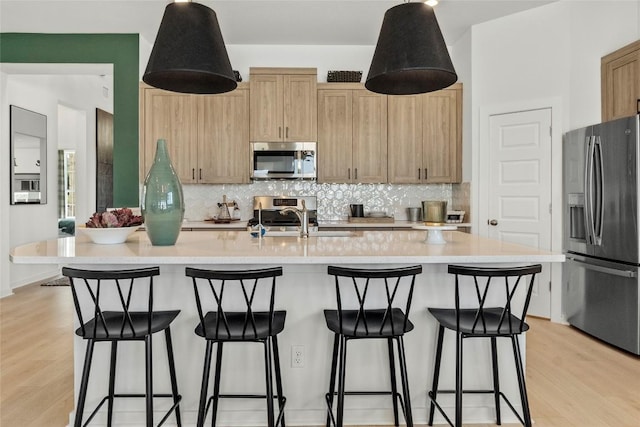 19512 Erna Dr, Pflugerville, TX 78660 - kitchen featuring stainless steel appliances, decorative backsplash, light countertops, light wood-style floors, and light brown cabinetry