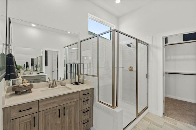 19512 Erna Dr, Pflugerville, TX 78660 - bathroom featuring a stall shower, vanity, a walk in closet, and recessed lighting