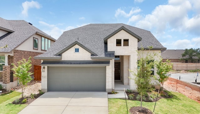 19512 Erna Dr, Pflugerville, TX 78660 - view of front of house featuring driveway, a shingled roof, brick siding, and an attached garage