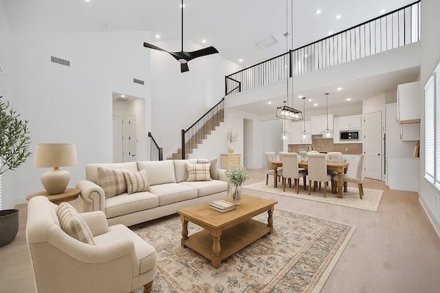 1601 Cardinal Ln, Round Rock, TX 78681 - living area featuring a towering ceiling, stairs, and recessed lighting