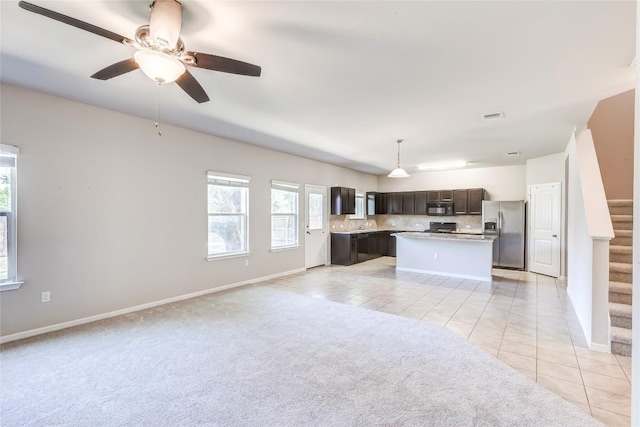 1710 Atlantica St, Cedar Park, TX 78613 - kitchen featuring stainless steel fridge with ice dispenser, dark brown cabinets, open floor plan, black microwave, and a kitchen island