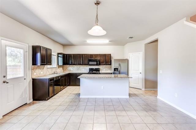 1710 Atlantica St, Cedar Park, TX 78613 - kitchen with black appliances, backsplash, dark brown cabinetry, a kitchen island, and pendant lighting