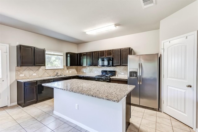 1710 Atlantica St, Cedar Park, TX 78613 - kitchen with black appliances, light tile patterned floors, decorative backsplash, and a kitchen island