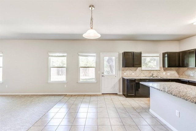 1710 Atlantica St, Cedar Park, TX 78613 - kitchen with dark brown cabinets, decorative backsplash, hanging light fixtures, light tile patterned floors, and light stone countertops