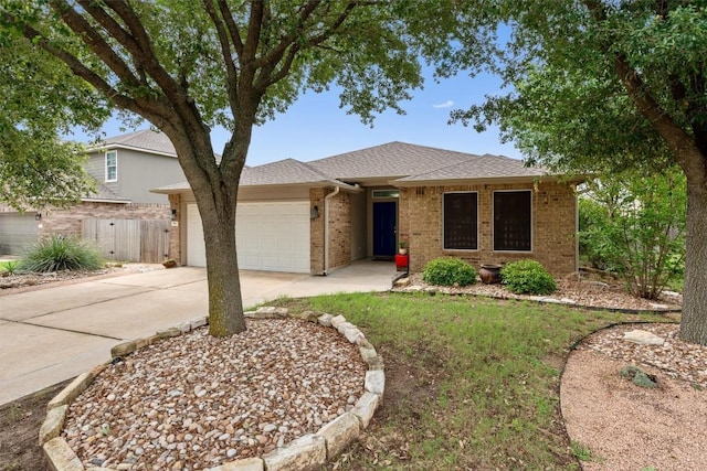 914 Flanagan Dr, Leander, TX 78641 - view of front of home with a garage, concrete driveway, brick siding, and roof with shingles