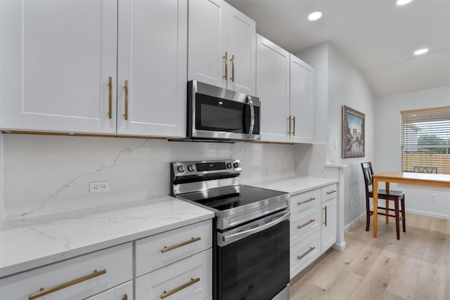 914 Flanagan Dr, Leander, TX 78641 - kitchen with appliances with stainless steel finishes, tasteful backsplash, recessed lighting, light wood-style flooring, and white cabinetry