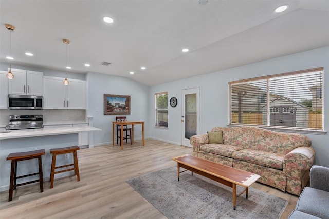 914 Flanagan Dr, Leander, TX 78641 - living room featuring healthy amount of natural light, lofted ceiling, light wood finished floors, and recessed lighting