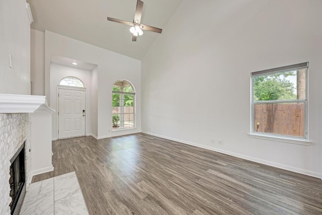216 Cassandra Dr, Hutto, TX 78634 - unfurnished living room featuring high vaulted ceiling, ceiling fan, wood finished floors, and a fireplace with flush hearth