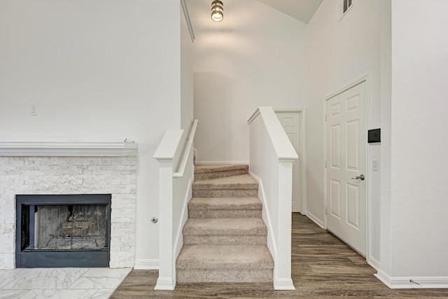 216 Cassandra Dr, Hutto, TX 78634 - stairway featuring wood finished floors, a fireplace, and high vaulted ceiling