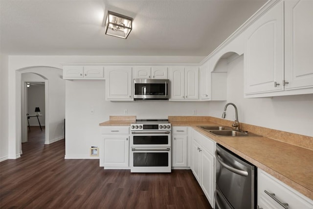 104 Live Oak Cir, Bertram, TX 78605 - kitchen with stainless steel appliances, arched walkways, white cabinetry, and dark wood finished floors