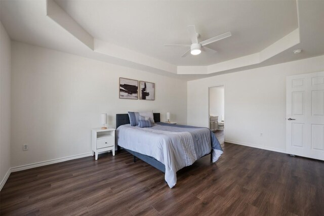 104 Live Oak Cir, Bertram, TX 78605 - bedroom featuring a raised ceiling, dark wood-style floors, ceiling fan, and connected bathroom