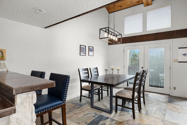229 Comanche Ln, Point Venture, TX 78645 - dining area featuring stone tile floors, french doors, a textured ceiling, and a chandelier