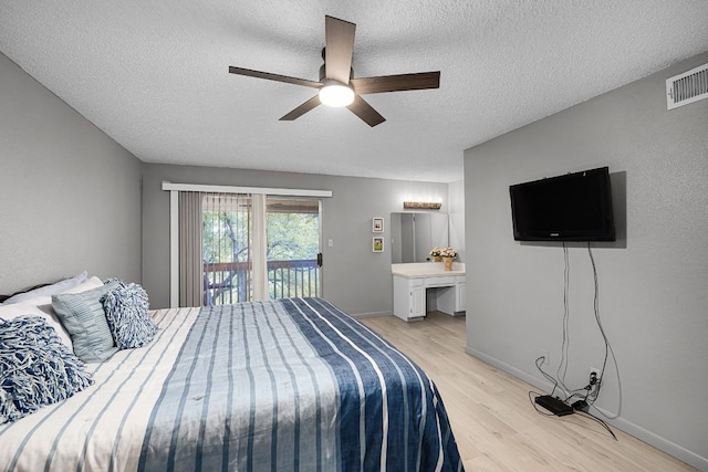 229 Comanche Ln, Point Venture, TX 78645 - bedroom with access to exterior, light wood finished floors, a textured ceiling, and ceiling fan