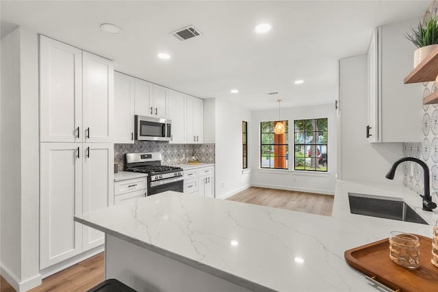 12416 Cassady Dr, Austin, TX 78727 - kitchen with stainless steel appliances, open shelves, light stone counters, light wood-type flooring, and recessed lighting