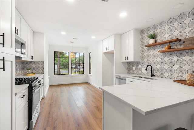 12416 Cassady Dr, Austin, TX 78727 - kitchen with stainless steel appliances, open shelves, a peninsula, light stone countertops, and light wood-type flooring