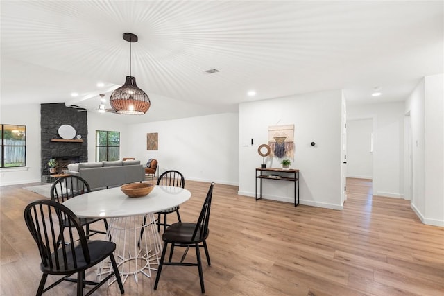 12416 Cassady Dr, Austin, TX 78727 - dining space featuring light wood finished floors, recessed lighting, a stone fireplace, and lofted ceiling