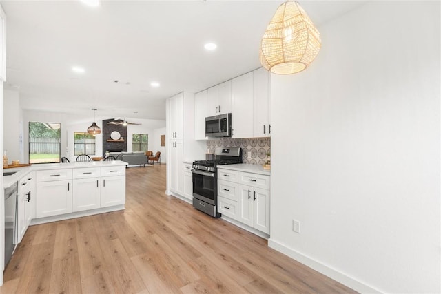 12416 Cassady Dr, Austin, TX 78727 - kitchen featuring appliances with stainless steel finishes, light wood-style flooring, tasteful backsplash, white cabinets, and light countertops