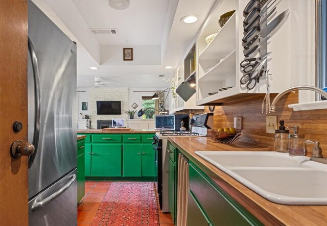 5201 Harvest Cir, Austin, TX 78745 - kitchen with appliances with stainless steel finishes, light tile patterned flooring, ceiling fan, green cabinets, and backsplash
