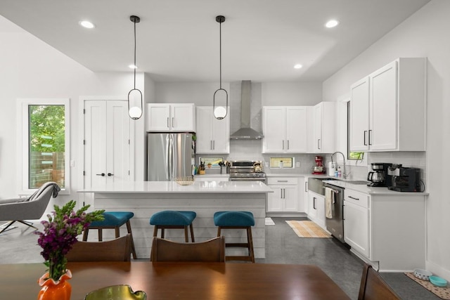 611 Gaylor St Unit 2, Austin, TX 78752 - kitchen with appliances with stainless steel finishes, wall chimney exhaust hood, a kitchen bar, white cabinets, and backsplash