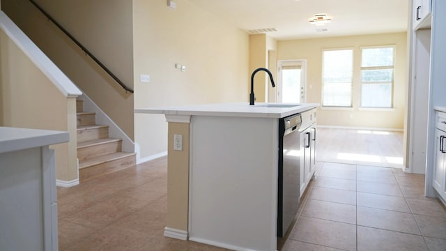 1024 Chad Loop, Round Rock, TX 78665 - kitchen featuring stainless steel dishwasher, light tile patterned floors, an island with sink, and light countertops