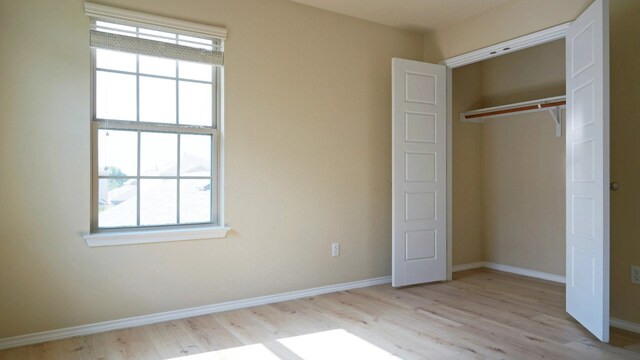 1024 Chad Loop, Round Rock, TX 78665 - unfurnished bedroom featuring multiple windows, light wood-style floors, and a closet