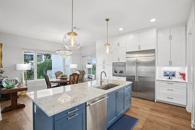 101 Cascading Water Pl, Austin, TX 78734 - kitchen featuring blue cabinets, appliances with stainless steel finishes, white cabinetry, light wood-style floors, and recessed lighting
