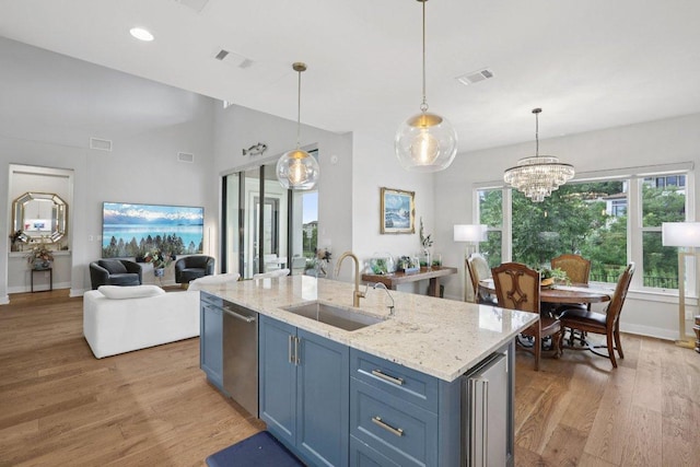 101 Cascading Water Pl, Austin, TX 78734 - kitchen with stainless steel dishwasher, light wood-style floors, a chandelier, light stone countertops, and recessed lighting
