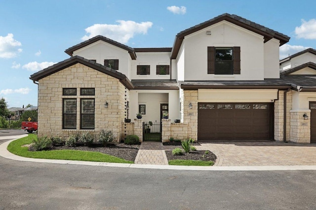101 Cascading Water Pl, Austin, TX 78734 - view of front facade with stone siding, an attached garage, stucco siding, driveway, and a gate