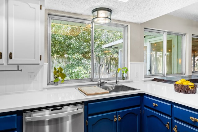 803 Lone Star Dr, Cedar Park, TX 78613 - kitchen with stainless steel dishwasher, blue cabinetry, a textured ceiling, plenty of natural light, and light countertops