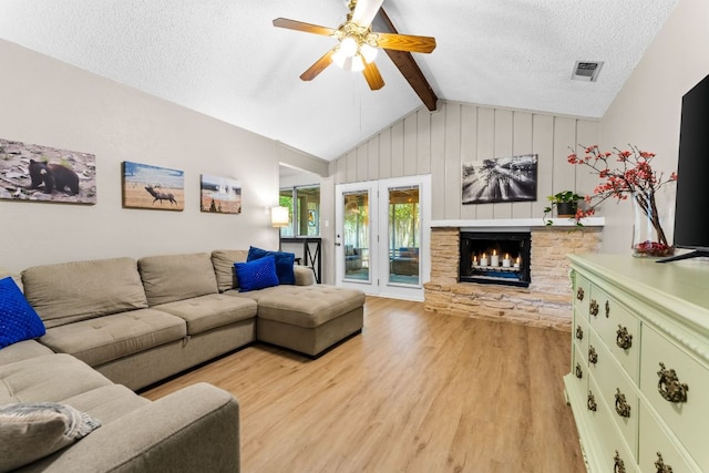 803 Lone Star Dr, Cedar Park, TX 78613 - living room featuring light wood-type flooring, ceiling fan, a fireplace, a textured ceiling, and wooden walls