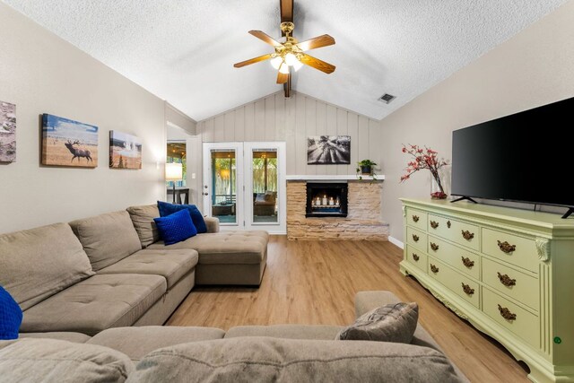 803 Lone Star Dr, Cedar Park, TX 78613 - living room featuring vaulted ceiling, ceiling fan, light wood-type flooring, a fireplace, and a textured ceiling