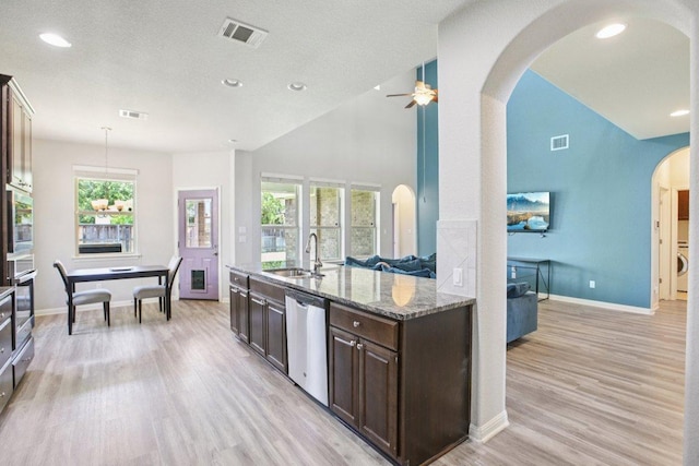 3200 Bravo Dr, Leander, TX 78641 - kitchen with stainless steel appliances, dark brown cabinets, arched walkways, light wood finished floors, and recessed lighting