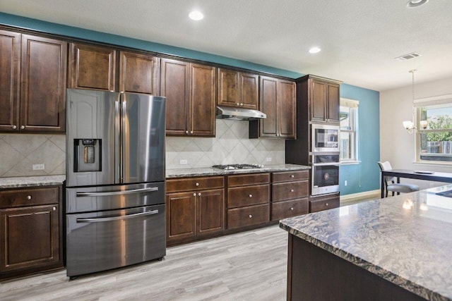 3200 Bravo Dr, Leander, TX 78641 - kitchen featuring stainless steel appliances, under cabinet range hood, light wood-type flooring, recessed lighting, and hanging light fixtures