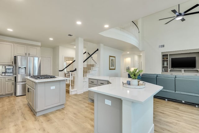 38 Cottondale Rd, The Hills, TX 78738 - kitchen featuring a center island, stainless steel appliances, open floor plan, a ceiling fan, and light wood-style flooring
