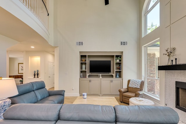 38 Cottondale Rd, The Hills, TX 78738 - living area featuring a towering ceiling, healthy amount of natural light, a fireplace, and light wood-style flooring