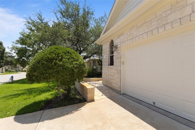 4921 Big Bend Trl, Georgetown, TX 78633 - view of side of home with stone siding, a garage, and a yard