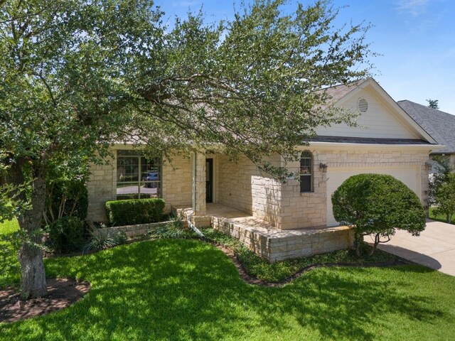 4921 Big Bend Trl, Georgetown, TX 78633 - view of front facade with a garage, a front yard, concrete driveway, and stone siding