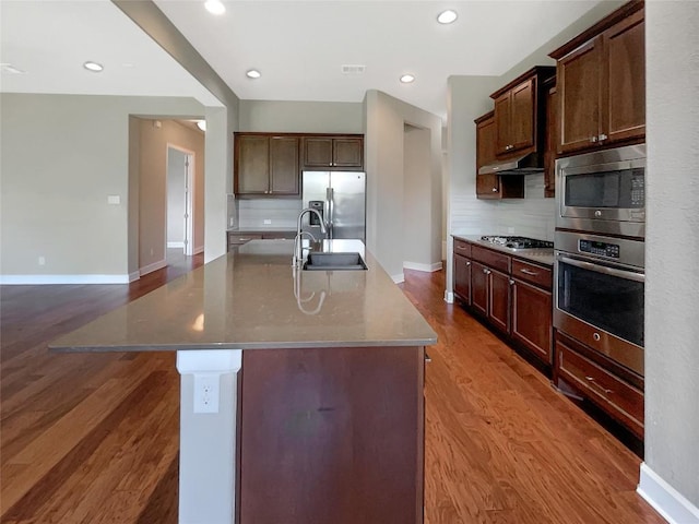 2302 Ponderosa Pass, Cedar Park, TX 78641 - kitchen featuring appliances with stainless steel finishes, wood finished floors, backsplash, an island with sink, and recessed lighting