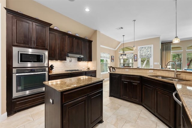 399 Whispering Wind Way, Austin, TX 78737 - kitchen with stainless steel appliances, backsplash, under cabinet range hood, light stone counters, and healthy amount of natural light