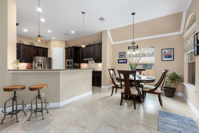 399 Whispering Wind Way, Austin, TX 78737 - kitchen featuring appliances with stainless steel finishes, backsplash, dark brown cabinets, a chandelier, and pendant lighting