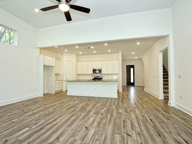 402 Zennia St, Austin, TX 78751 - unfurnished living room featuring light wood-type flooring, stairway, recessed lighting, and a ceiling fan