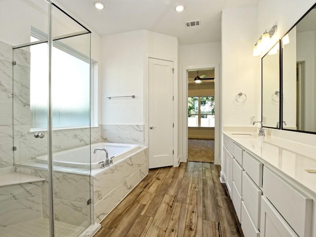 402 Zennia St, Austin, TX 78751 - full bath with a bath, wood finished floors, double vanity, a marble finish shower, and a ceiling fan