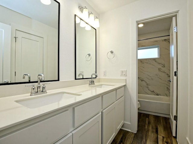 402 Zennia St, Austin, TX 78751 - full bathroom with double vanity, wood finished floors, and shower / bathtub combination
