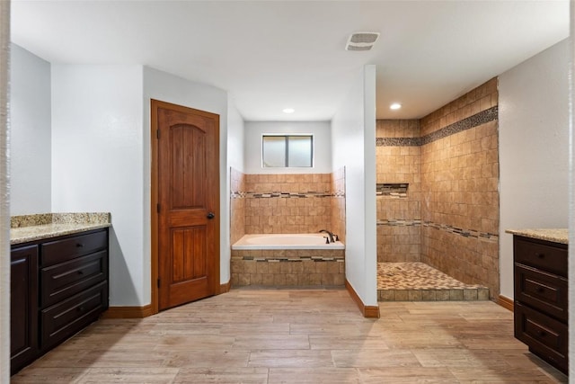 108 Whispering Pines Dr, Bastrop, TX 78602 - full bathroom featuring a garden tub, wood finished floors, a walk in shower, and vanity