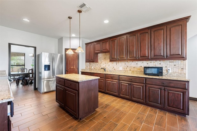 108 Whispering Pines Dr, Bastrop, TX 78602 - kitchen with stainless steel fridge, black microwave, backsplash, dark wood-style floors, and recessed lighting