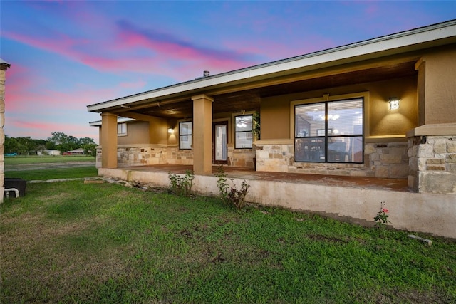 108 Whispering Pines Dr, Bastrop, TX 78602 - view of property exterior with stone siding, a yard, stucco siding, and covered porch