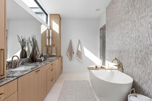 2701 Greenlee Dr, Austin, TX 78703 - full bathroom featuring a freestanding bath, double vanity, tile patterned floors, and tile walls