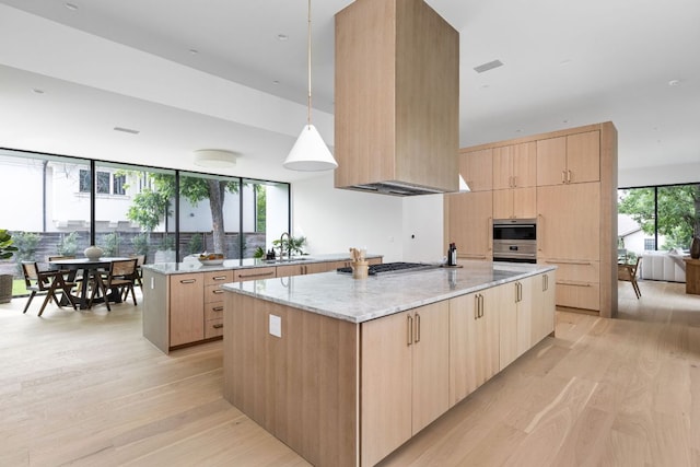2701 Greenlee Dr, Austin, TX 78703 - kitchen with modern cabinets, light brown cabinetry, light wood-style flooring, and a large island with sink