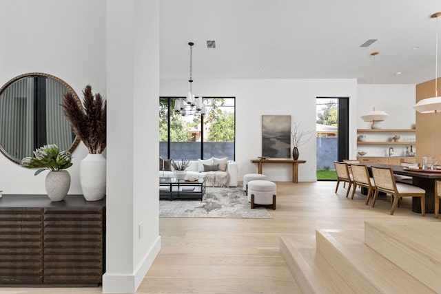 2701 Greenlee Dr, Austin, TX 78703 - living room featuring light wood-type flooring, a chandelier, and healthy amount of natural light